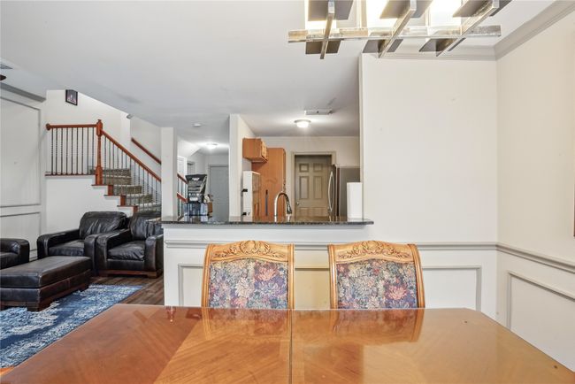 Dining space featuring wood finished floors, stairs, and wainscoting | Image 10