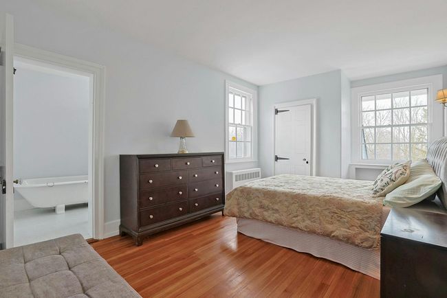 Bedroom featuring multiple windows and wood finished floors | Image 23