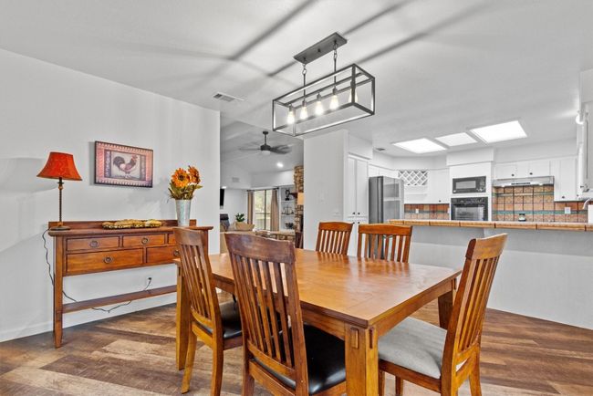 Dining room with ceiling fan, a skylight, and dark wood-type flooring | Image 10