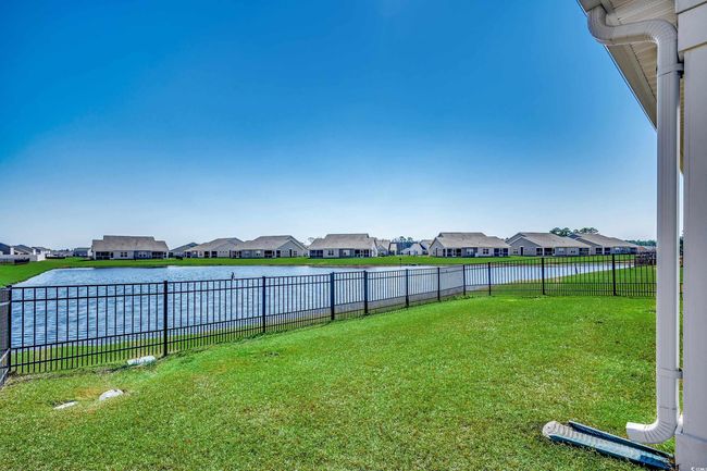 View of yard with a residential view, a water view, and a fenced backyard | Image 6