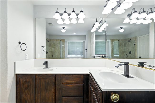 Bathroom featuring a stall shower, double vanity, and a chandelier | Image 31