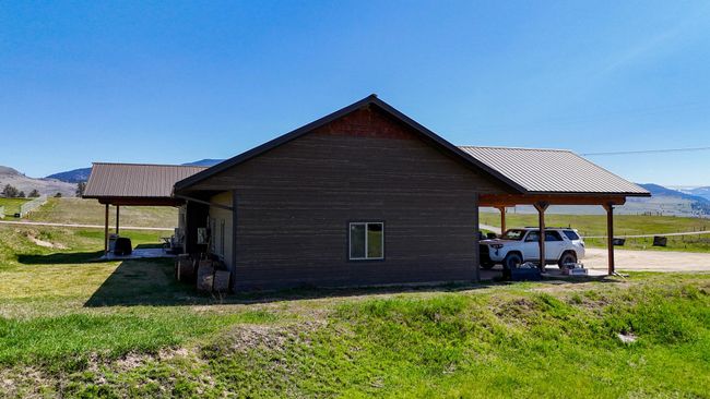 View of side of property featuring metal roof, a mountain view, a carport, and a yard | Image 37