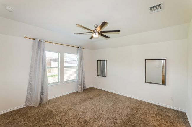 Carpeted empty room featuring a ceiling fan and baseboards | Image 20