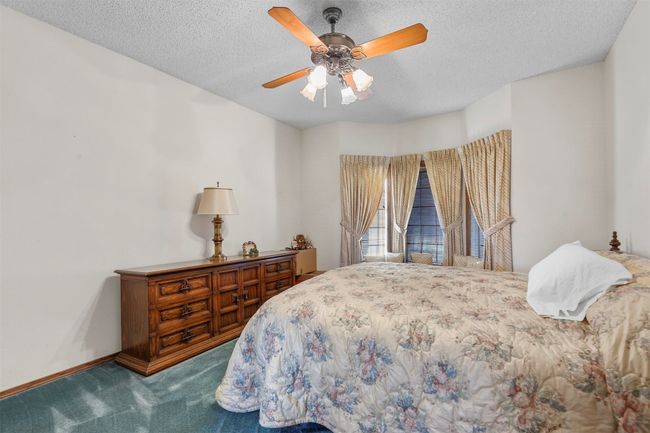 Bedroom with ceiling fan, a textured ceiling, and carpet | Image 21