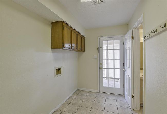 Large laundry room with a half bathroom coming in from the detached garage. | Image 9