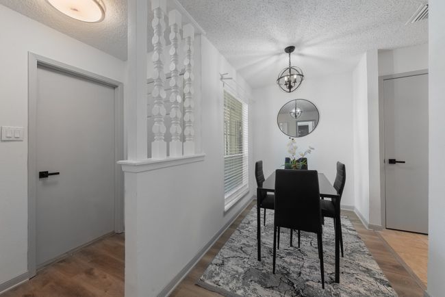 Dining room featuring an inviting chandelier, wood finished floors, a textured ceiling, and visible vents | Image 16