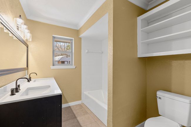 Bathroom with ornamental molding, tile patterned flooring, a sink, and toilet | Image 18