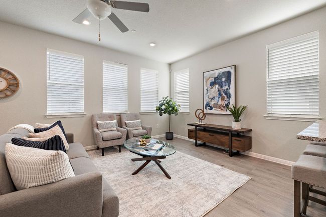 Living area with light wood finished floors, ceiling fan, baseboards, and recessed lighting | Image 8