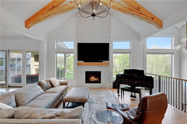 Living room featuring a chandelier, beam ceiling, and high vaulted ceiling | Image 12