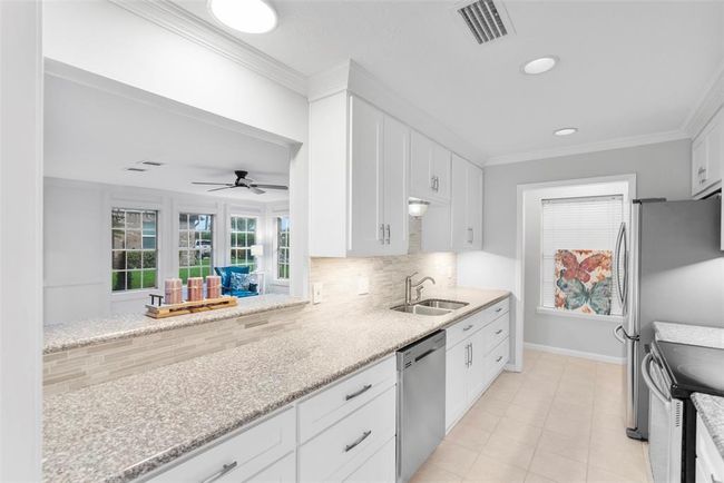 The kitchen features a breakfast bar to remain connected to the living space. | Image 10