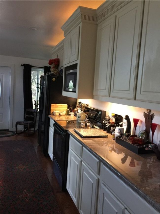Large cabinet space with granite counters, black appliances | Image 8