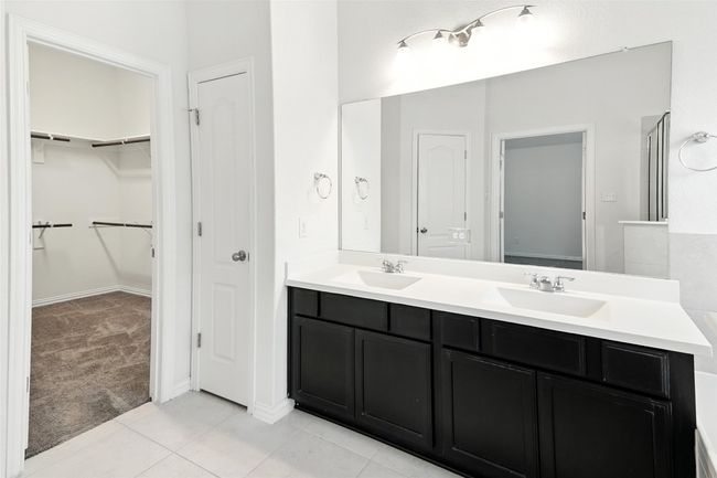 Full bathroom featuring double vanity, a walk in closet, and tile patterned flooring | Image 30