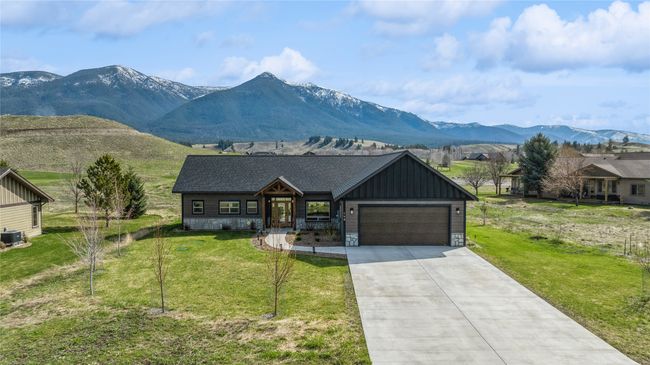 View of front of property featuring a garage, a front yard, driveway, and board and batten siding | Image 34