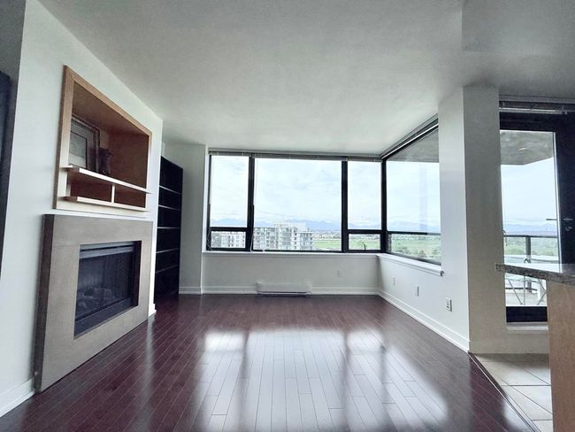 Unfurnished living room with wood finished floors and a fireplace | Image 6