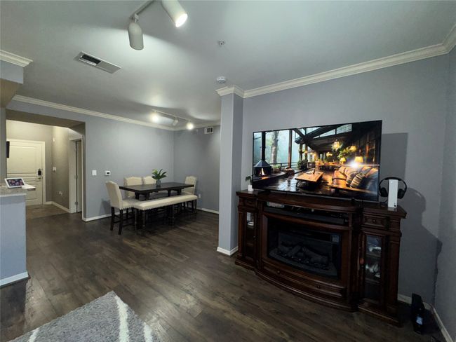 Living room featuring ornamental molding, dark hardwood / wood-style floors, and track lighting | Image 27