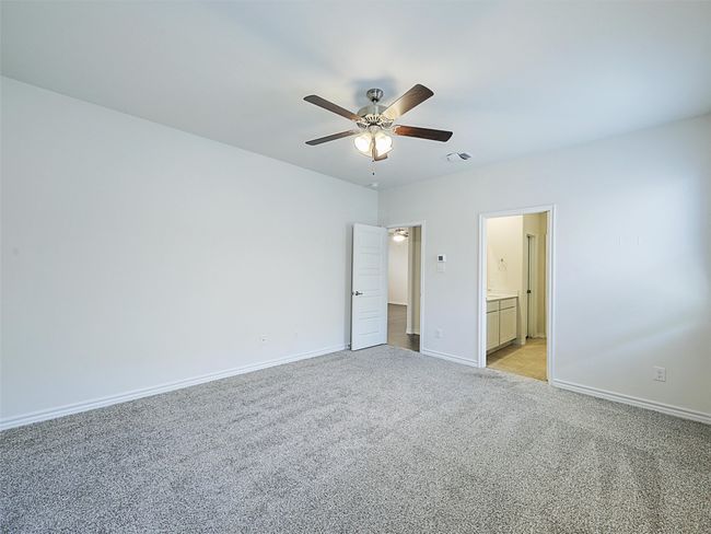 Unfurnished bedroom with light carpet, ensuite bath, and ceiling fan | Image 14