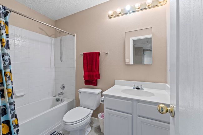 Bathroom with vanity, shower / bath combo, a textured ceiling, and toilet | Image 26