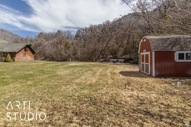 View of yard with a mountain view, a storage unit, and an outdoor structure | Image 42