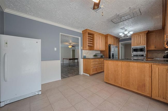 View into the den and kitchen from the breakfast room. | Image 8