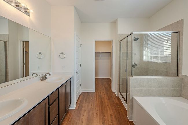 Bathroom featuring a sink, a garden tub, and a shower stall | Image 9
