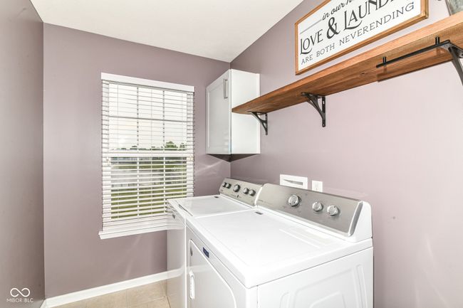 laundry room with cabinet space, separate washer and dryer, healthy amount of natural light, and baseboards | Image 27