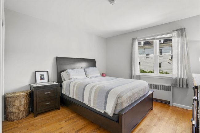 Bedroom featuring radiator heating unit and light wood floors | Image 14