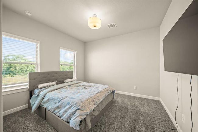 Bright secondary bedroom with soft carpet and neutral tones, ideal for guests or family members. | Image 30