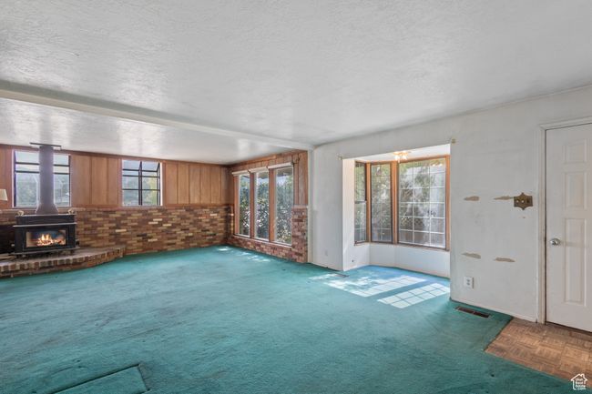 Unfurnished living room featuring a textured ceiling and carpet floors | Image 7