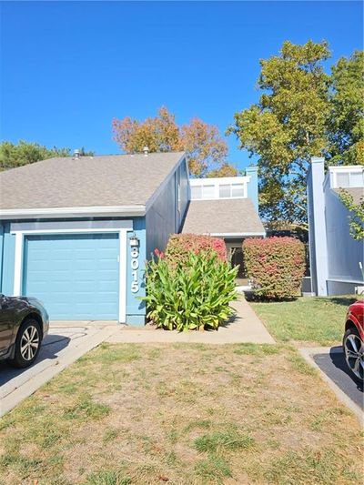 View of front of property featuring 1 car garage and extensive landscaping. | Image 1