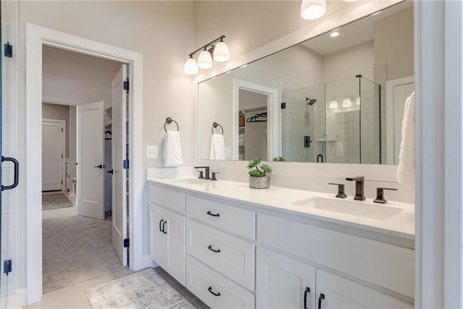 Bathroom with a shower stall, double vanity, a sink, and a walk in closet | Image 20