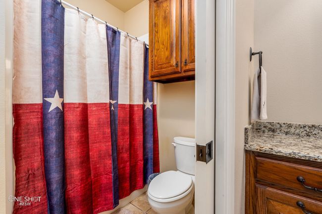 Full bath featuring toilet, tile patterned floors, vanity, and a shower with curtain | Image 31
