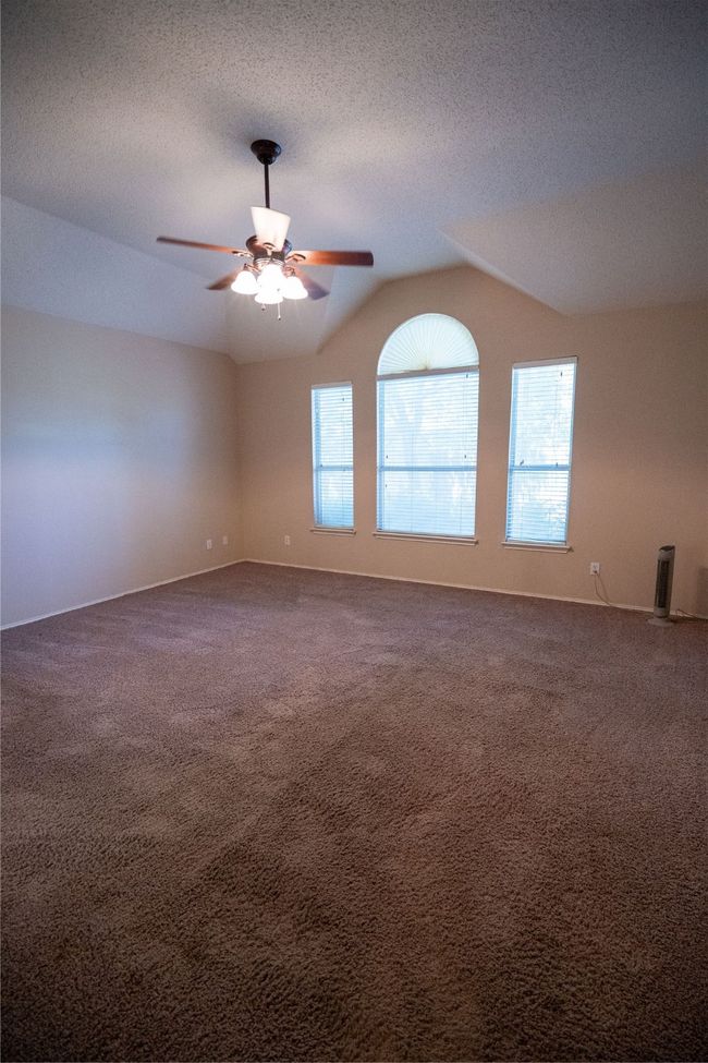 Primary bedroom with vaulted ceiling, carpet, &ceiling fan | Image 11