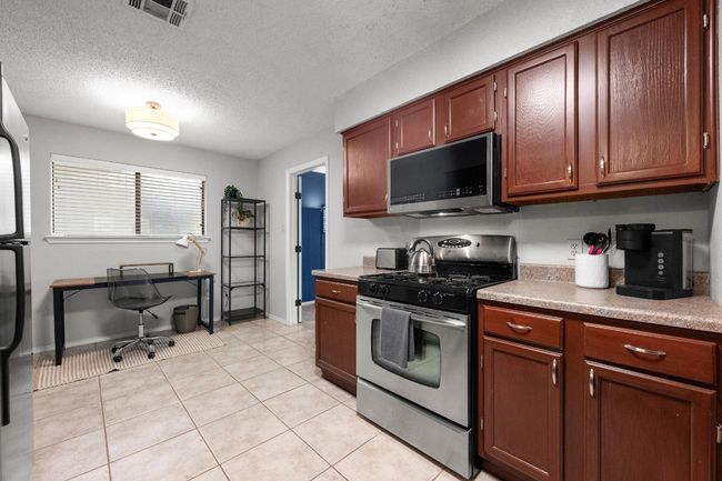Kitchen with stainless steel appliances and breakfast area. Door on right leads to giant bedroom, bonus room and laundry. | Image 10