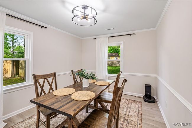 Dining room with a chandelier, plenty of natural light, and light wood finished floors | Image 5