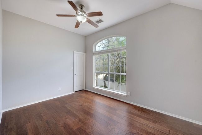 Empty room featuring dark wood-style floors, baseboards, a ceiling fan, and vaulted ceiling | Image 27