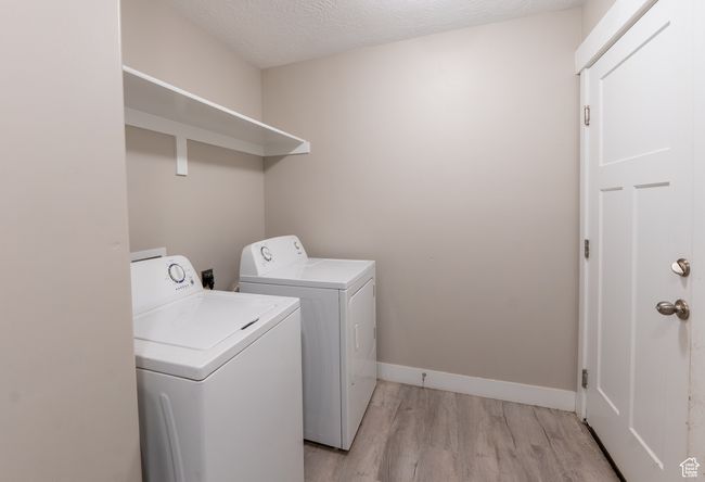 Washroom featuring washing machine and clothes dryer and light wood-style flooring | Image 14