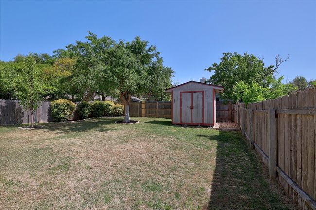 View of yard featuring a fenced backyard, an outdoor structure, and a storage unit | Image 25