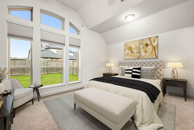 What a wonderful place to come home to! This stunning primary suite greets you with plush carpet floors, neutral paint, high ceiling, ceiling fan with lighting, lovely arched windows with blinds allowing in natural light brightening up this spacious primary bedroom with extra space for a seating area. *virtual staged* | Image 10