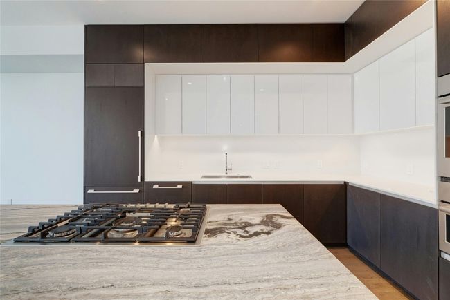 Kitchen featuring modern cabinets, white cabinets, appliances with stainless steel finishes, light countertops, and a sink | Image 12