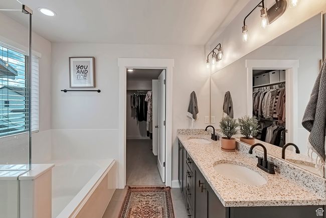Full bathroom featuring a bath, double vanity, tile patterned floors, a walk in closet, and recessed lighting | Image 15
