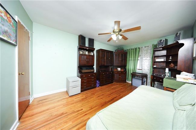 Bedroom with wood finished floors and a ceiling fan | Image 14