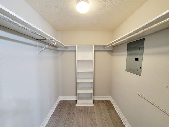 Walk in closet with electric panel and hardwood / wood-style flooring | Image 13
