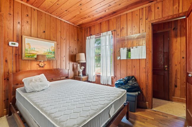 Bedroom featuring wood walls, hardwood / wood-style floors, and wooden ceiling | Image 21