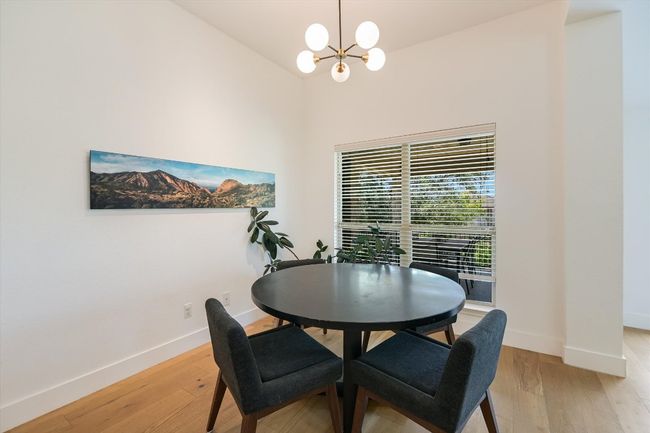Dining space featuring a chandelier, light wood-type flooring, baseboards, and vaulted ceiling | Image 10