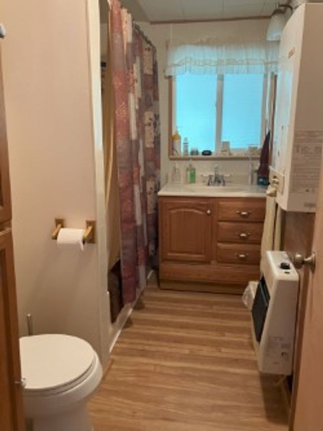 Full bathroom with wood finished floors, vanity, and a shower with curtain | Image 27