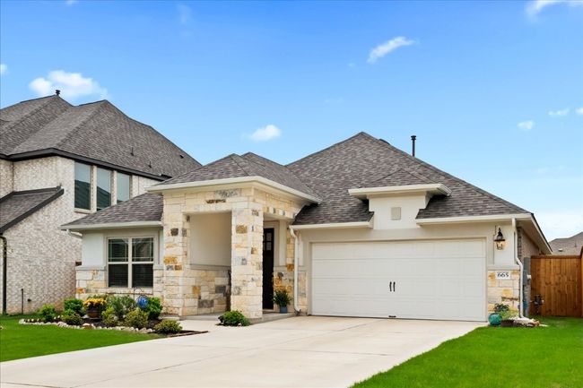French country style house with fence, an attached garage, a shingled roof, concrete driveway, and a front lawn | Image 39
