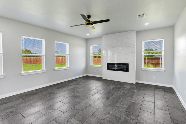 Unfurnished living room with a ceiling fan, a fireplace, recessed lighting, and baseboards | Image 8