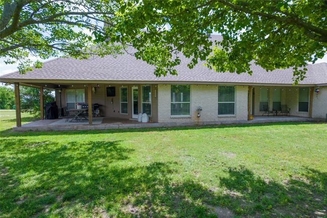 Rear view of house featuring roof with shingles, a patio, and a lawn | Image 30