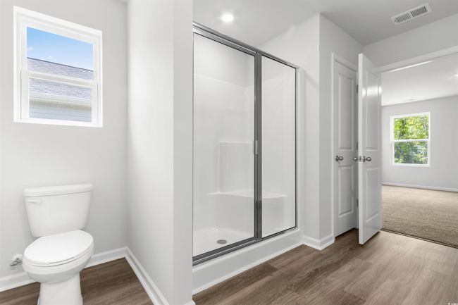 Bathroom featuring toilet, an enclosed shower, and hardwood / wood-style floors | Image 23