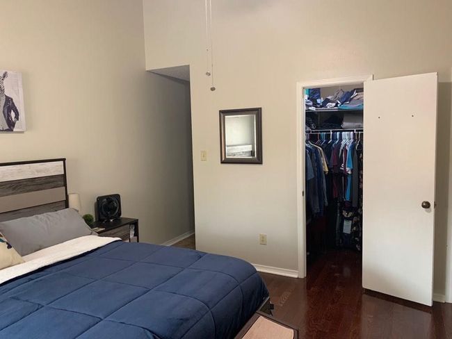 Bedroom featuring wood finished floors, a spacious closet, baseboards, and a closet | Image 8
